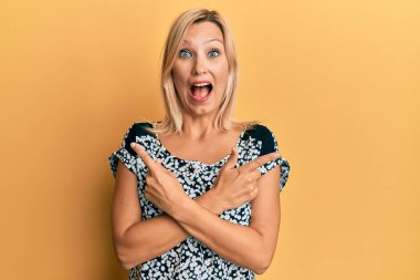 Orta yaşlı beyaz kadın farklı yönleri işaret ederek çılgınlığı kutluyor ve başarı için hayrete düşüyor.. 