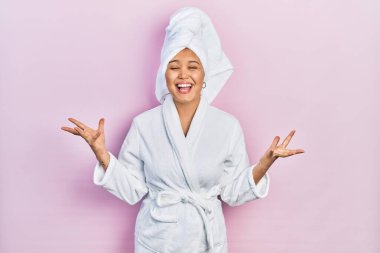 Duş havlusu şapkası takan ve bornoz giyen genç İspanyol kız başarının çılgınlığını kollarını kaldırarak ve gözleri kapalı heyecanla bağırarak kutluyor. Kazanan konsept 