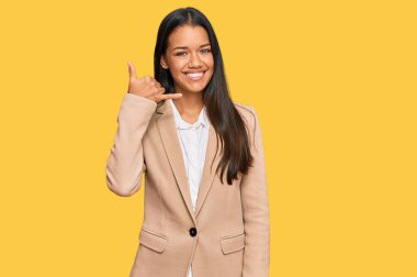 Güzel İspanyol kadın iş ceketi giyiyor gülümsüyor telefonla el ve parmaklarıyla jest yapıyor telefonda konuşuyor gibi. iletişim kavramları. 