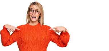 Güzel sarışın kadın gündelik kıyafetler ve gözlük takıyor. Kendine güvenen, gülümseyen, kendini gururlu ve mutlu gösteren.. 