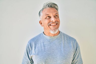 Orta yaşlı, İspanyol, kır saçlı, gülümseyen adam şehirde mutlu mesut dikiliyor..