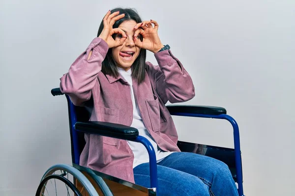Молодая Брюнетка Сидящая Инвалидной Коляске Делает Нормальный Жест Бинокль Торчащий — стоковое фото