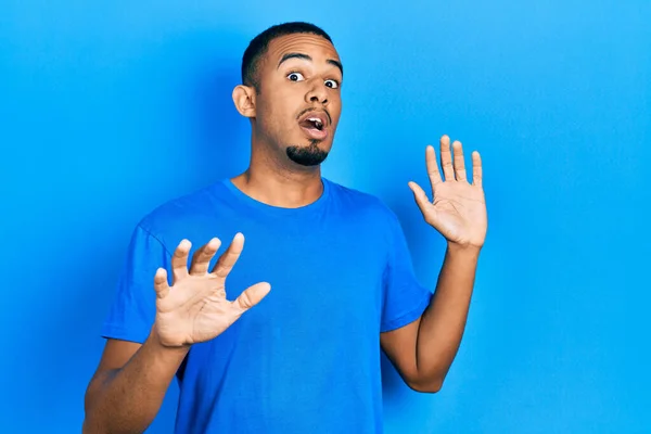 身穿休闲蓝T恤的年轻的非洲裔美国人害怕而害怕 用恐惧的表情 用手停止手势 震惊地大叫 恐慌概念 — 图库照片