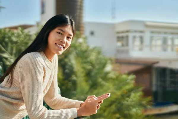 在城市里 年轻的亚洲女人用智能手机开心地笑着 — 图库照片