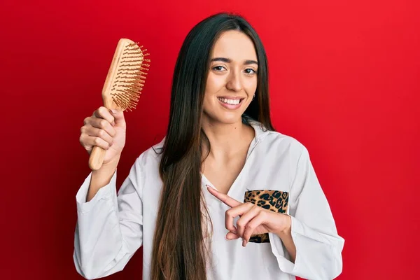 Young Hispanic Girl Holding Hairbrush Smiling Happy Pointing Hand Finger — ストック写真