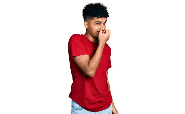 Young African American Man Wearing Casual Red Shirt Smelling Something — Stock Photo, Image