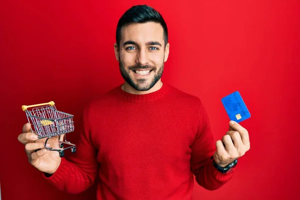 Ung Latinamerikan Man Som Håller Små Snabbköp Kundvagn Och Kreditkort — Stockfoto