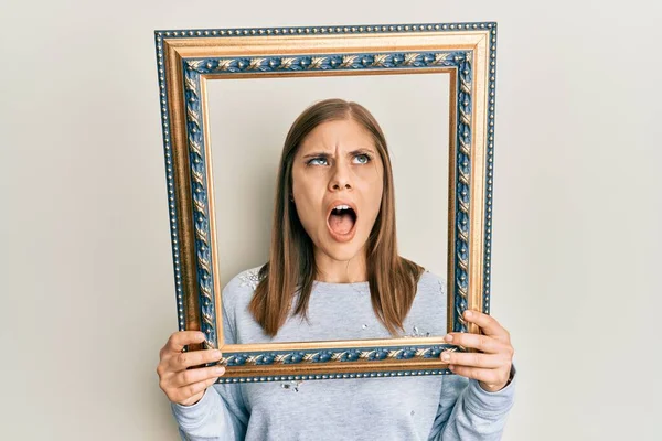 Beautiful Caucasian Woman Holding Empty Frame Angry Mad Screaming Frustrated — Stock Photo, Image
