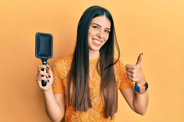 Jonge Spaanse Vrouw Met Haarborstel Glimlachend Gelukkig Positief Duim Omhoog — Stockfoto