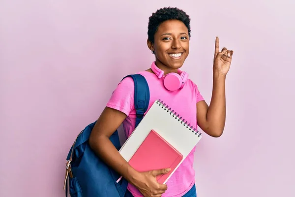 Young African American Girl Wearing School Bag Holding Books Surprised — Stock Photo, Image