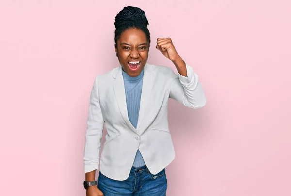 若いアフリカ系アメリカ人の女性がビジネス服を着て怒りと怒りで叫んでいる間に怒りと怒りの拳を上げる怒っている 怒りと攻撃的な考え方 — ストック写真