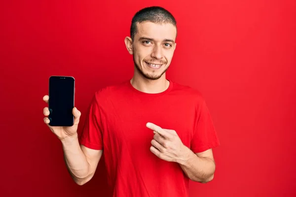 Latynoski Młody Człowiek Trzyma Smartfona Pokazując Pusty Ekran Uśmiechnięty Szczęśliwy — Zdjęcie stockowe