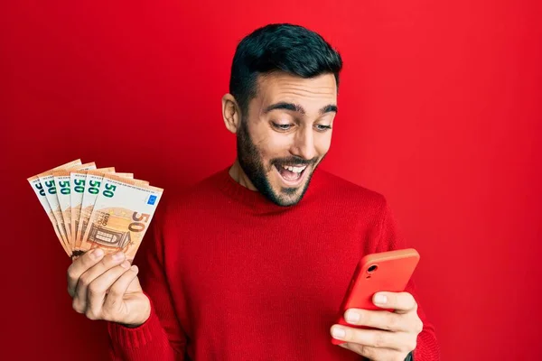 Fiatal Spanyol Férfi Okostelefont Használ Eurós Bankjegyekkel Mosolyogva Hangosan Nevetve — Stock Fotó