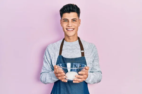 Jovem Hispânico Vestindo Avental Segurando Tigela Massa Pão Olhando Positivo — Fotografia de Stock