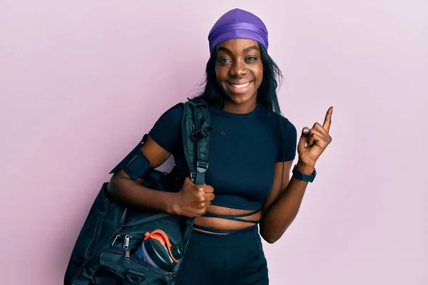 Ung Afrikansk Amerikansk Kvinna Håller Gym Väska Ler Glad Pekar — Stockfoto