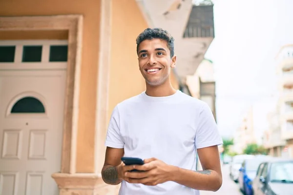 Junger Lateinischer Mann Lächelt Glücklich Mit Smartphone Durch Die Stadt — Stockfoto