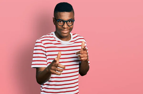 年轻的非洲裔美国人 身穿休闲装 戴着眼镜 手指指向镜头 脸上洋溢着欢乐和滑稽的表情 充沛的精力和活力 — 图库照片
