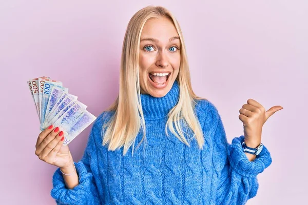 Mladá Blondýnka Dívka Drží Švédské Koruny Bankovky Ukazující Palcem Nahoru — Stock fotografie