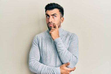 Gündelik kıyafetler giyen genç İspanyol adam şüphe üzerine yoğunlaşmıştı. Parmakları çenesinde ve yukarı bakıyordu. 
