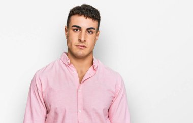 Yüzünde ciddi bir ifade olan gündelik kıyafetler giyen İspanyol genç adam. Basit ve doğal bir şekilde kameraya bakıyorsun.. 