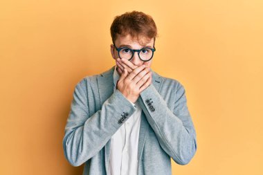 Genç, beyaz, inek, gözlüklü, hippi görünümlü, papyonlu, ağzı yanlışlıkla ellerle kapatan genç bir adam. gizli kavram. 