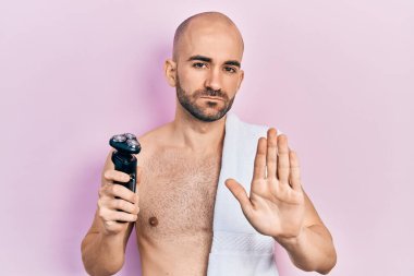 Genç, kel bir adam, elinde elektrikli jilet tutuyordu. Elinde dur işareti vardı. Ciddi ve kendinden emin bir ifadeyle. 