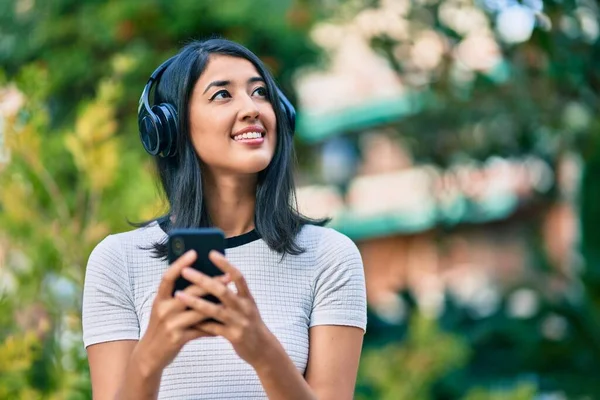 Genç Spanyol Kadın Şehirde Akıllı Telefon Kulaklık Kullanarak Mutlu Bir — Stok fotoğraf