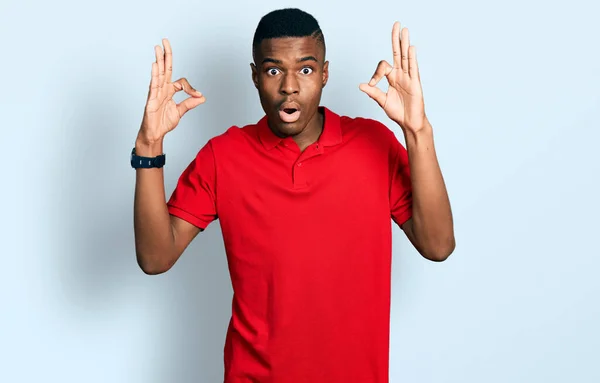 Jovem Afro Americano Vestindo Camiseta Vermelha Casual Parecendo Surpreso Chocado — Fotografia de Stock