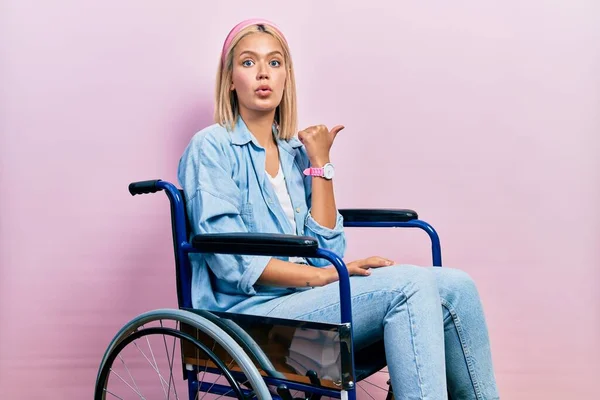 Красивая Блондинка Сидит Инвалидной Коляске Удивлен Указывая Пальцем Сторону Открытый — стоковое фото