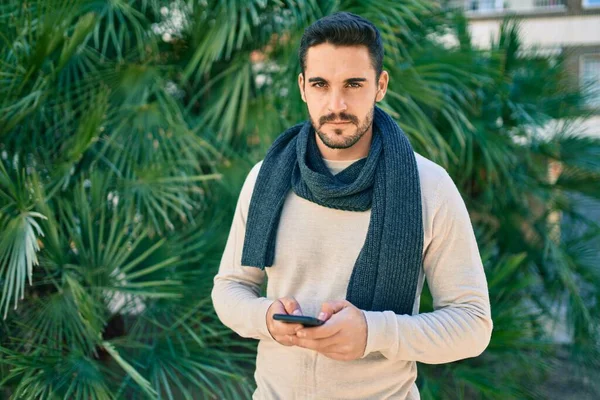 Ung Latinamerikan Man Med Allvarliga Uttryck Använder Smartphone Parken — Stockfoto