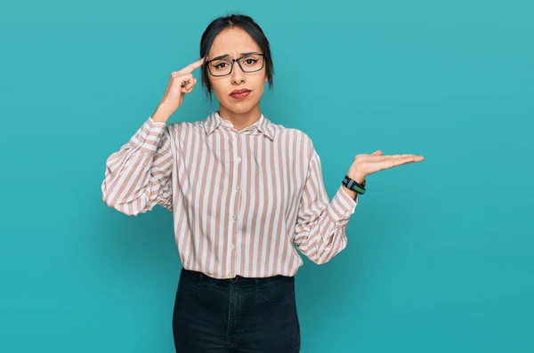 Ung Latinamerikansk Flicka Bär Casual Kläder Och Glasögon Förvirrad Och — Stockfoto