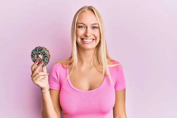 Giovane Ragazza Bionda Possesso Ciambella Guardando Positivo Felice Piedi Sorridente — Foto Stock