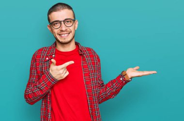 İspanyol genç adam gündelik giysiler giyip kameraya hayret ediyor ve gülümsüyor.. 