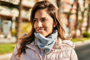 Genç İspanyol kadın gülümseyerek şehirde mutlu mesut dikiliyor..