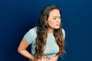 hazımsızlık, acı verici bir hastalık ve midesi ağrıyan gündelik giysiler giyen genç İspanyol kız. Ağrı kavramı. 