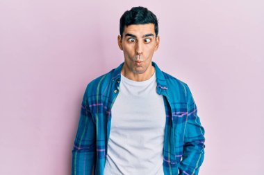 Yakışıklı, günlük kıyafetler giyen, dudaklarıyla balık suratı yapan, çılgın ve komik bir jest yapan bir İspanyol. Komik ifade. 