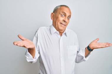 Yakışıklı, beyaz gömlekli, cahil ve elleri havada, kafası karışık bir adam. şüphe kavramı. 