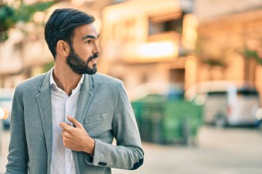 Genç İspanyol işadamı gülümseyerek şehirde mutlu mesut duruyor..