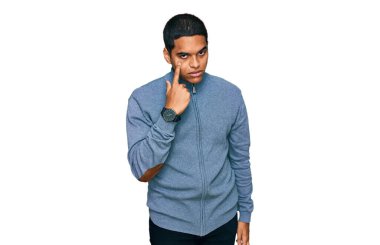 Gündelik kazak giyen genç, yakışıklı İspanyol adam jestini izlerken gözüne bakıyor, şüpheli bir ifade. 