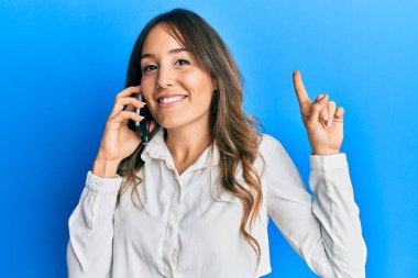 Genç esmer bir kadın akıllı telefondan konuşuyor ciddi bir yüz ifadesi var eli çenesinde soruyu düşünüyor, kafa karıştırıcı bir fikir. 