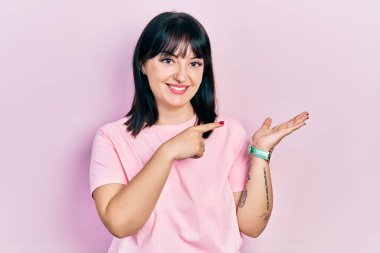 Gündelik kıyafetler giyen genç İspanyol kadın kameraya hayret ediyor ve gülümsüyor.. 