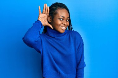 Genç Afro-Amerikalı kadın, günlük kıyafetler giyip, sırıtarak dedikodu ve dedikoduları dinliyor. Sağırlık kavramı. 