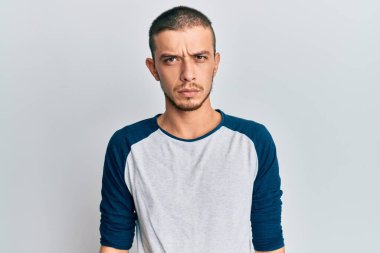 Gündelik kıyafetler giyen İspanyol genç adam şüpheci ve gergin, sorun yüzünden surat asıyor. negatif kişi. 