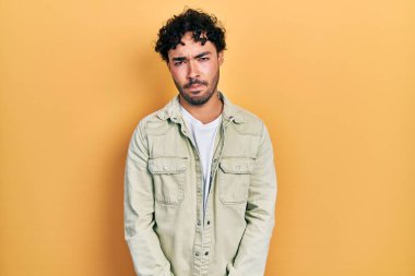 Gündelik kıyafetler giyen, kuşkucu ve gergin genç İspanyol bir adam sorun yüzünden surat asıyor. negatif kişi. 
