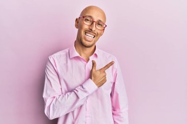 Sakallı, sıradan kıyafetler giyen, gözlüklü, neşeli gülümseyen, eli ve parmağı yanda olan kel bir adam. 