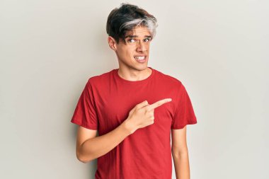 Gündelik kıyafetler giyen genç İspanyol adam endişeli ve gergin bir şekilde işaret ediyor. 