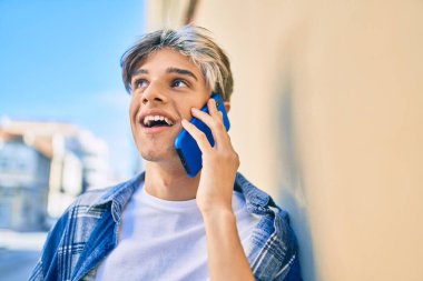 Genç İspanyol adam gülümsüyor. Şehirdeki akıllı telefondan konuşuyor..