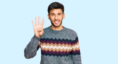 Kış süveteri giyen genç yakışıklı adam gülümseyerek kendinden emin ve mutlu gülümserken dört numarayı gösteriyor ve işaret ediyor.. 