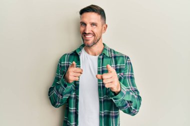 Sakallı, sıradan giyinmiş, mutlu ve komik yüzüyle kamerayı gösteren yakışıklı bir adam. iyi enerji ve titreşimler. 