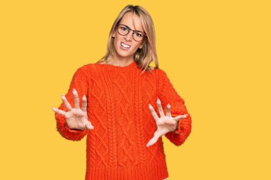 Arka planda gözlüklü genç ve güzel bir kadın iki eliyle hareket ediyor, güler yüzlü, güler yüzlü.